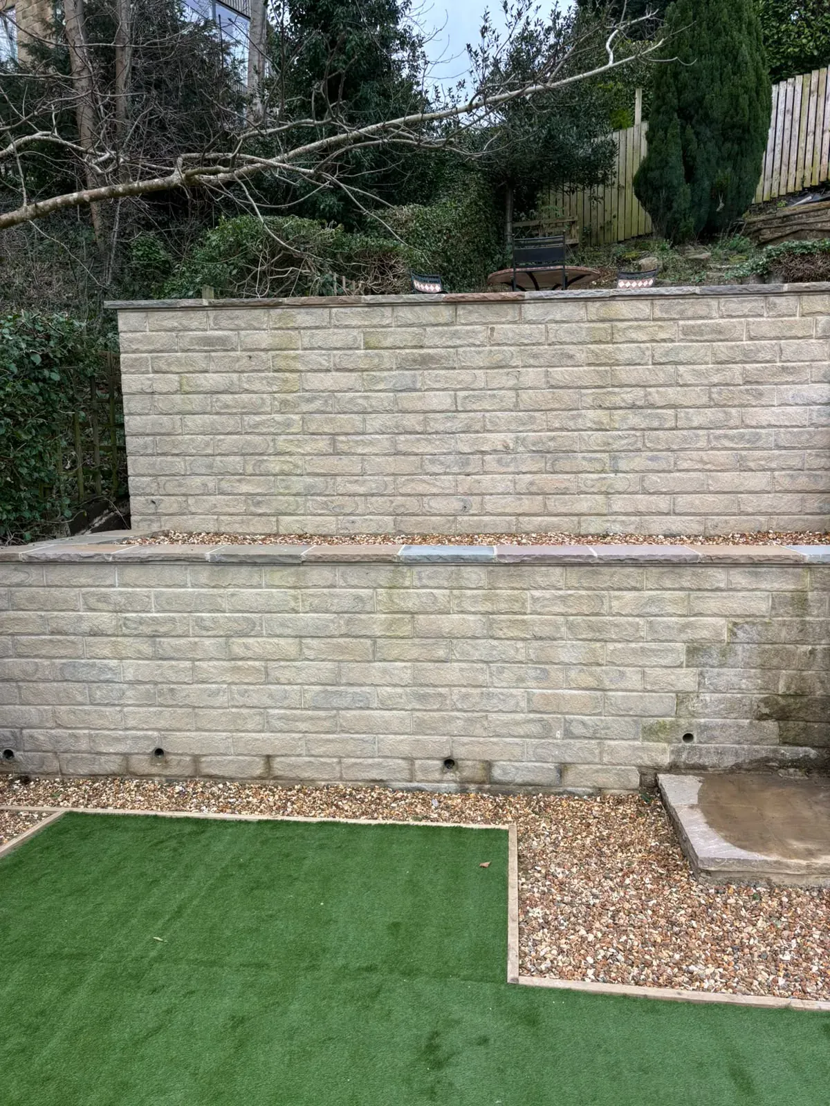 Artificial grass raised stone planter completed by Crown Hill Contracting