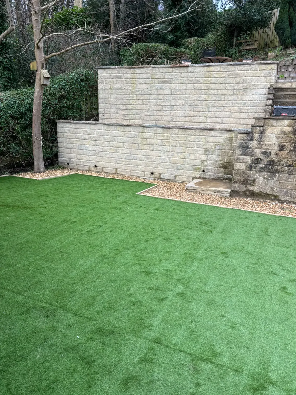 Artificial grass stone walled garden completed by Crown Hill Contracting