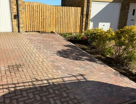 Block paved driveway extension prepared beside a stone garage