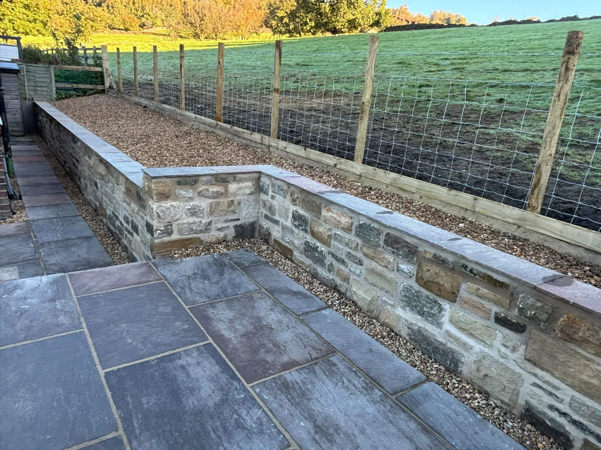 Capped stone retaining wall completed by Crown Hill Contracting