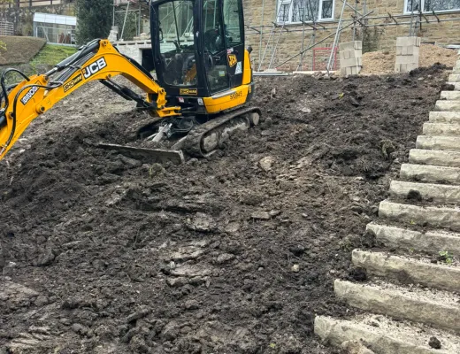 Mini digger excavating a sloping rear garden for a new flight of stone steps