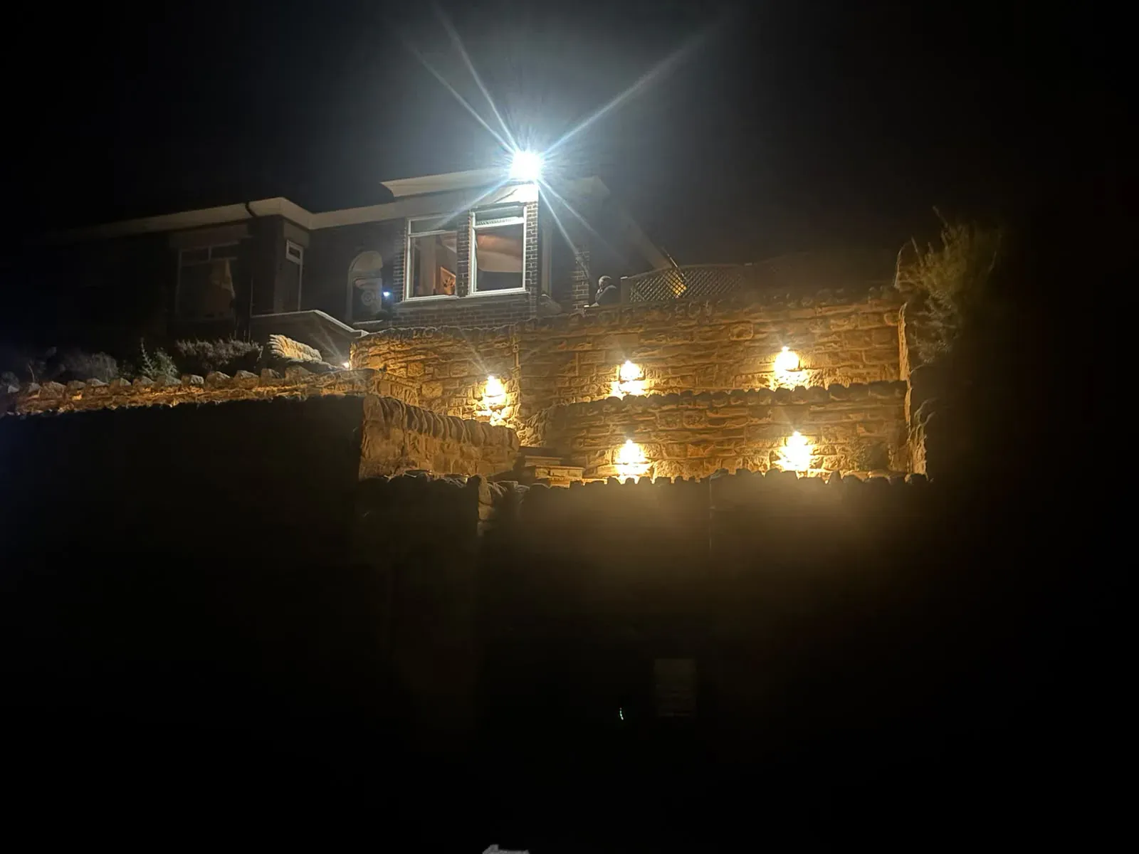 Illuminated retaining wall wide view completed by Crown Hill Contracting