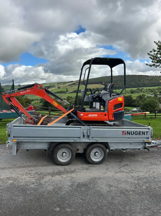 Compact excavator ready for landscaping and groundworks on a rural site