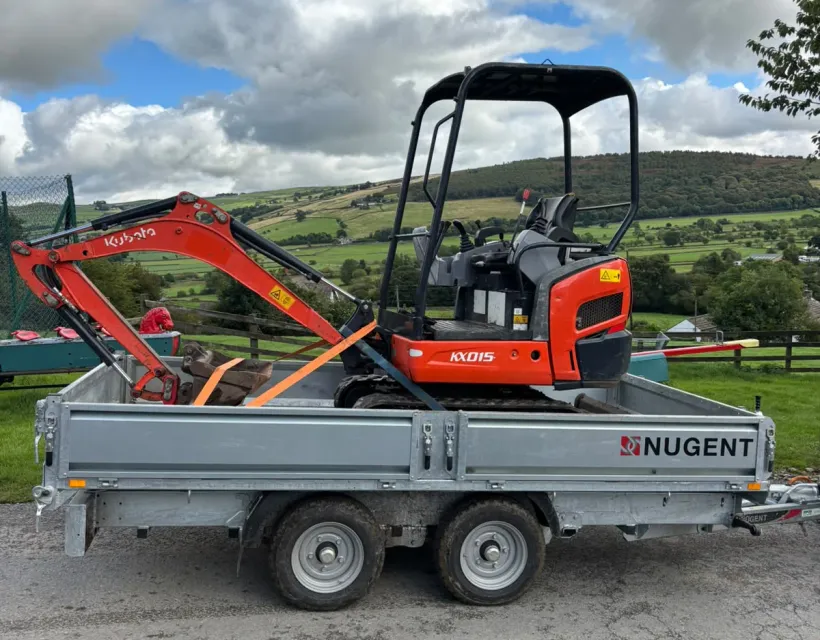 Compact excavator ready for landscaping and groundworks on a rural site