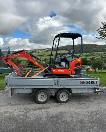 Compact excavator ready for landscaping and groundworks on a rural site