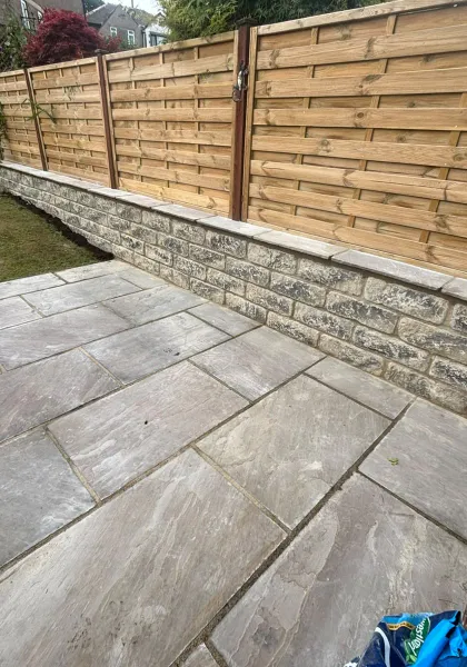 New grey porcelain patio laid beside a fresh timber boundary fence