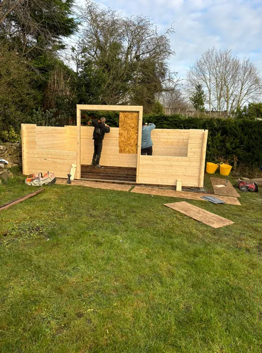Timber pagoda under construction on a new base in a back garden