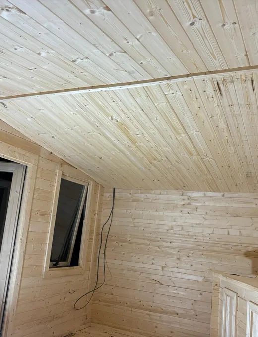 Pine clad interior of a newly built timber pagoda with window and door fitted