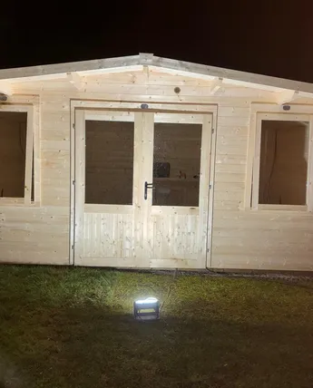 Finished timber pagoda with double doors, lit up at dusk